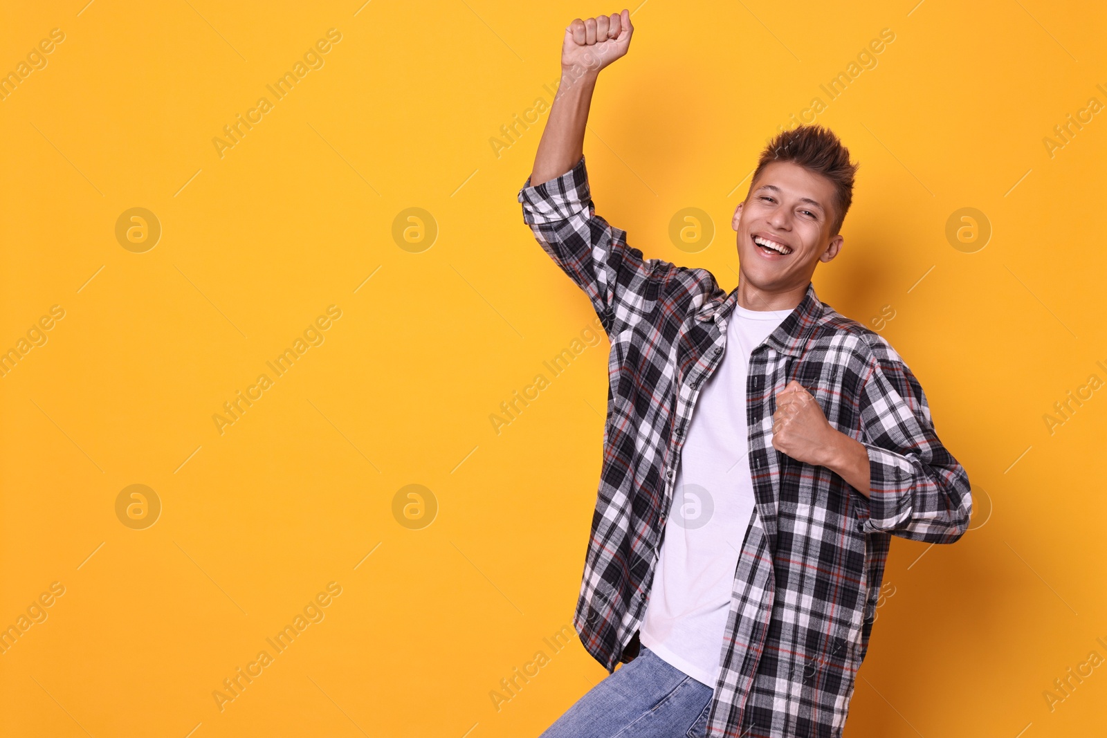 Photo of Happy young student on yellow background, space for text