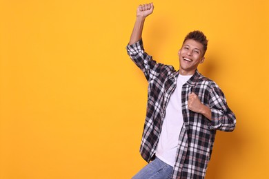 Happy young student on yellow background, space for text