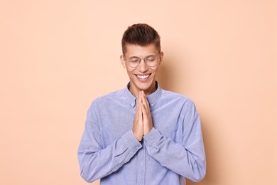 Photo of Young student grateful about his good exam result on beige background