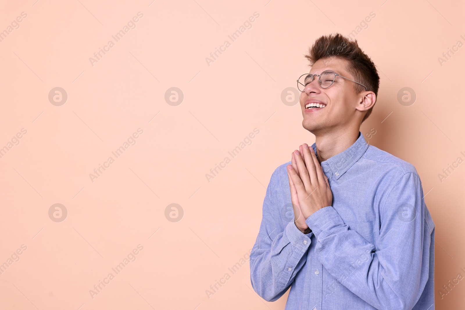 Photo of Young student grateful about his good exam result on beige background, space for text