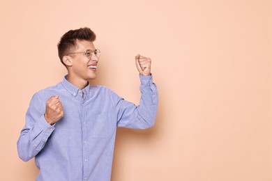 Photo of Happy young student on beige background, space for text