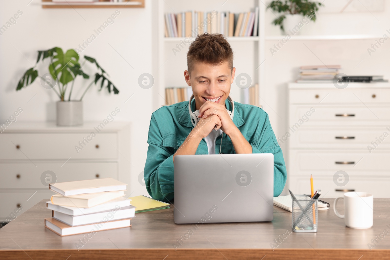 Photo of Student studying with laptop at table indoors