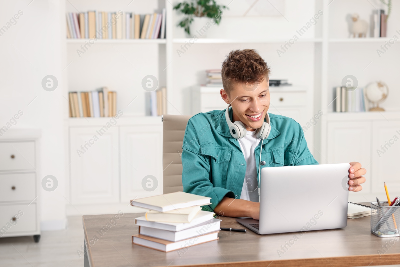 Photo of Student studying with laptop at table indoors