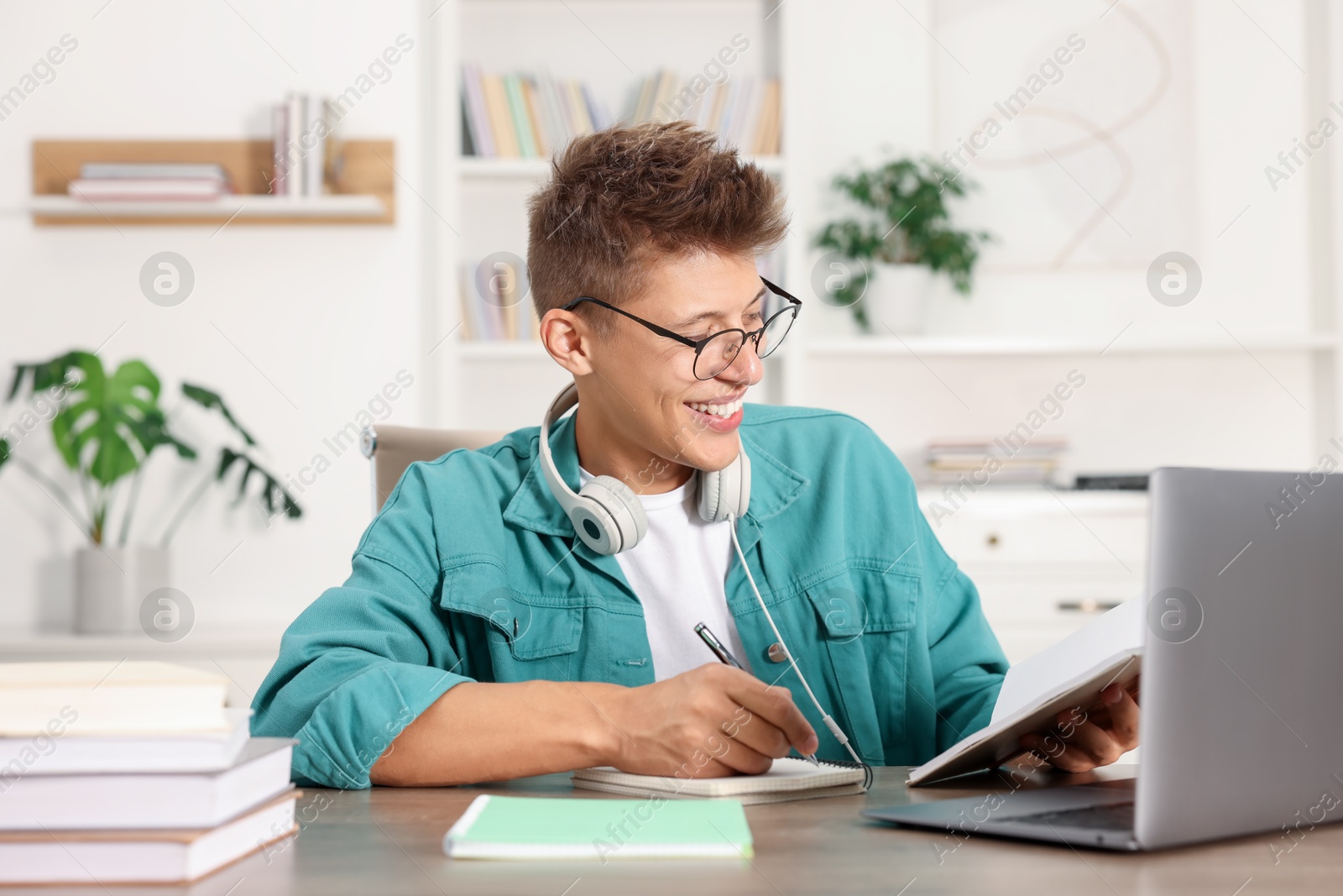 Photo of Student in glasses studying at table indoors