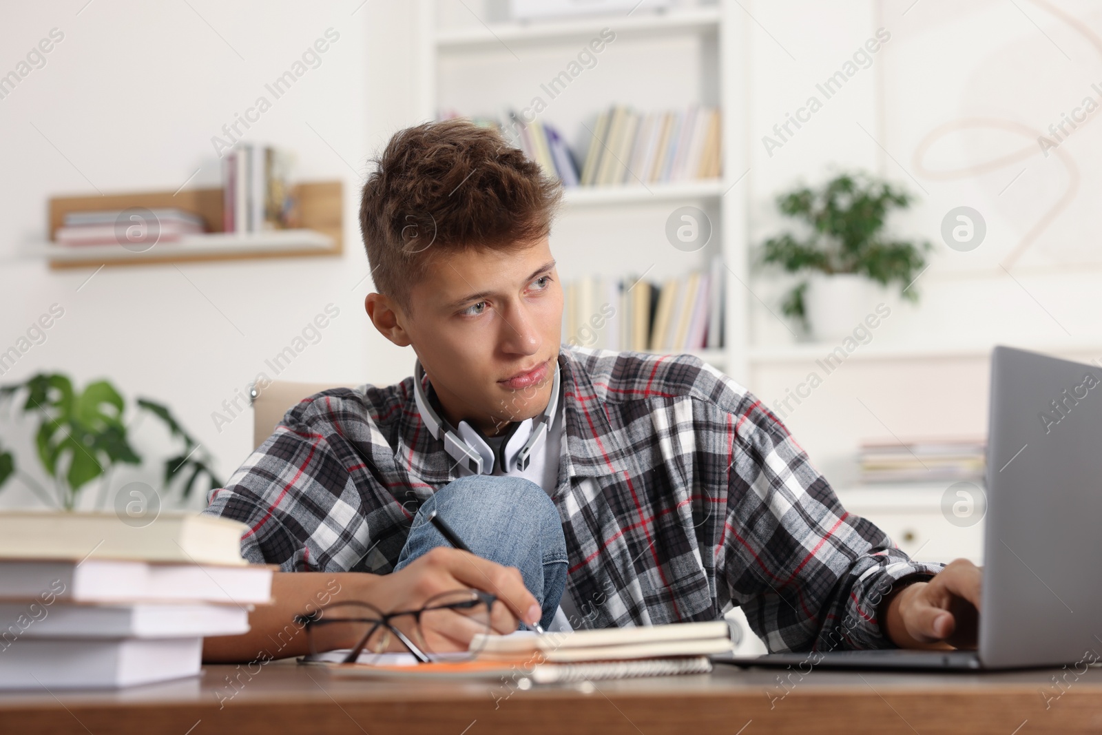 Photo of Student studying with laptop at table indoors