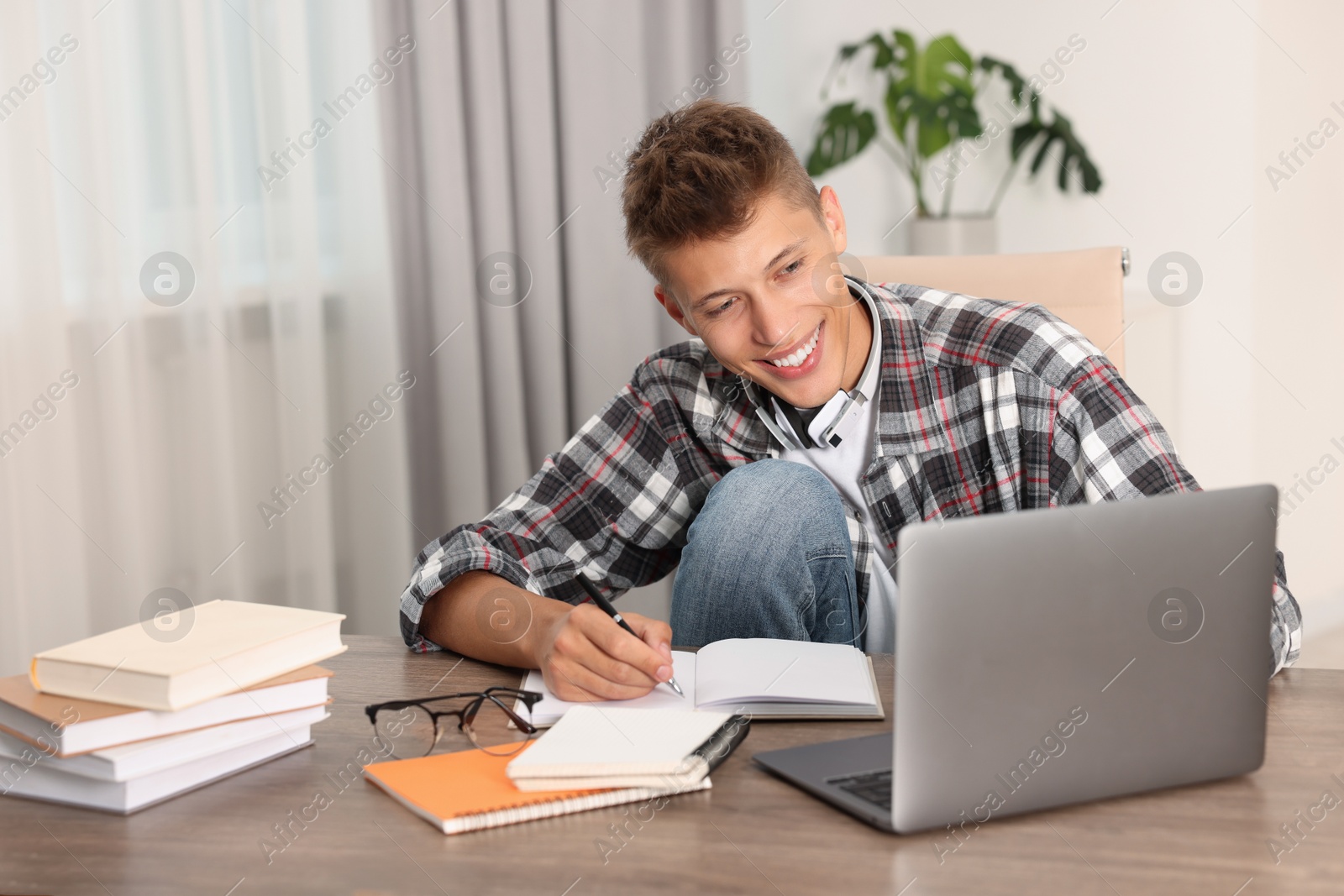 Photo of Student studying with laptop at table indoors