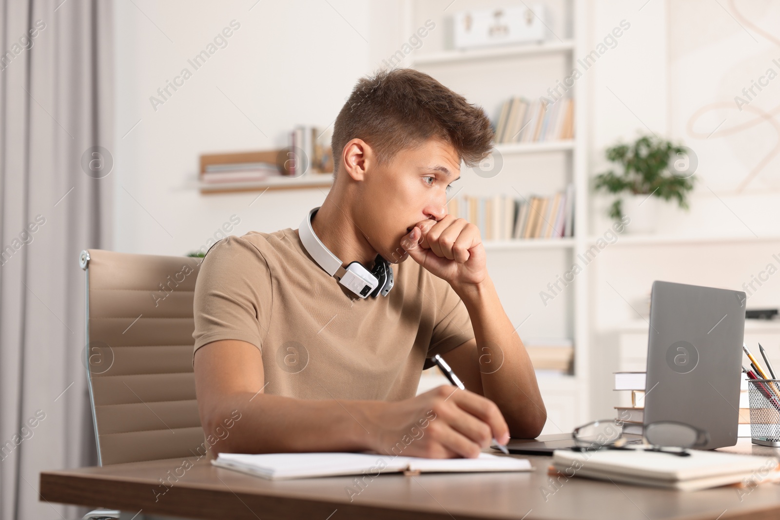 Photo of Student studying with laptop at table indoors