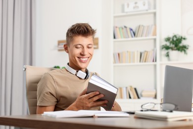 Student with book studying at table indoors