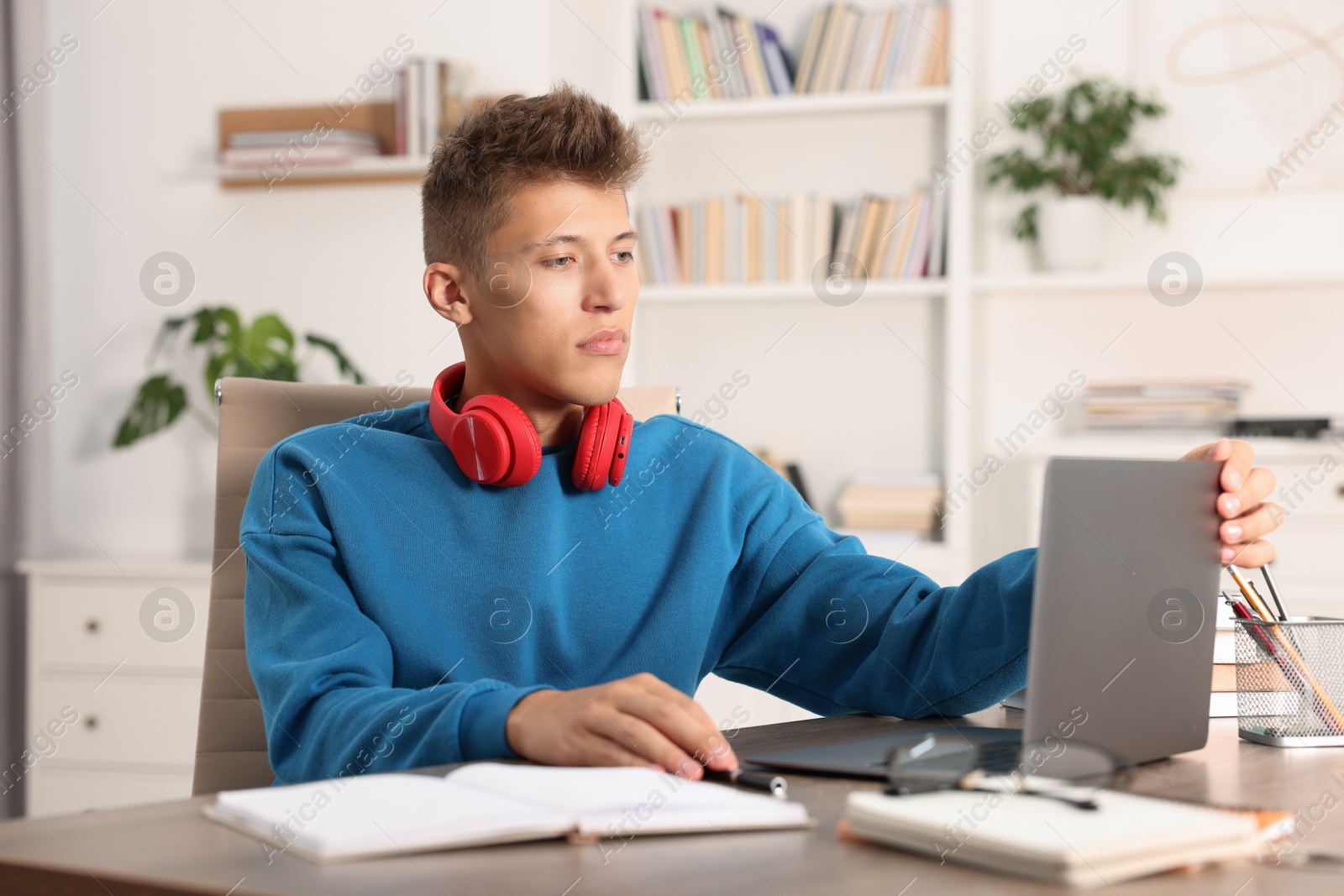 Photo of Student studying with laptop at table indoors