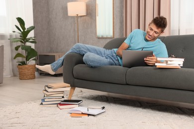 Student studying with laptop on sofa at home