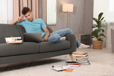 Student studying with laptop on sofa at home