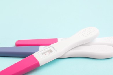 Photo of Pregnancy tests on light blue background, closeup