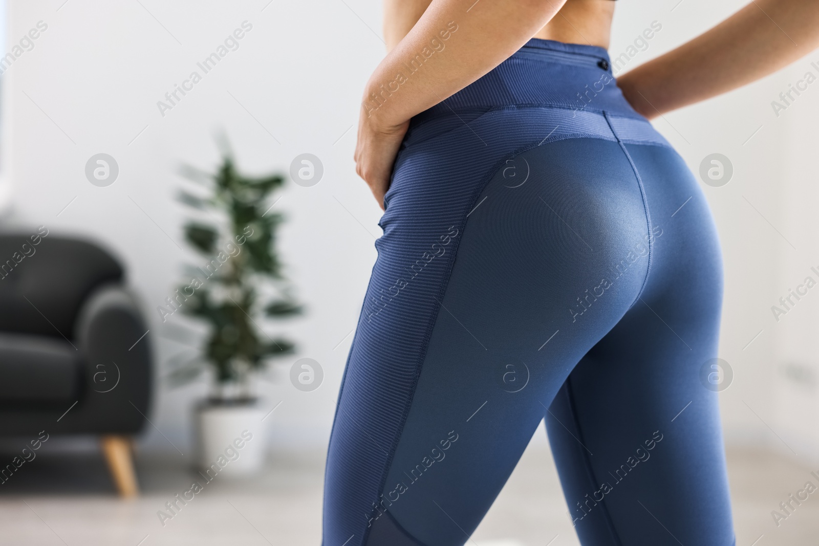 Photo of Woman wearing blue sports leggings indoors, closeup