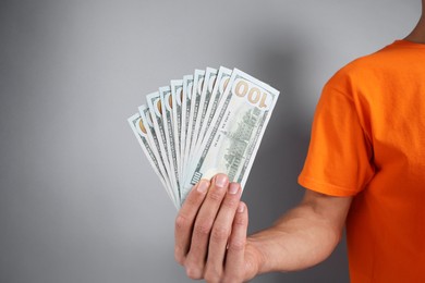 Photo of Man with dollar banknotes on grey background, closeup