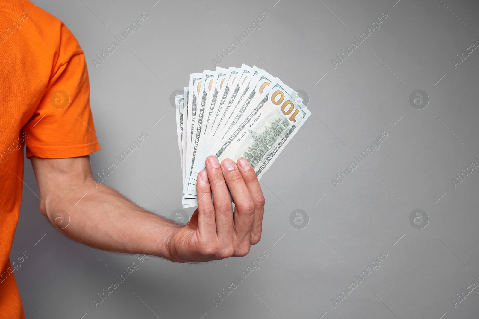 Photo of Man with dollar banknotes on grey background, closeup. Space for text