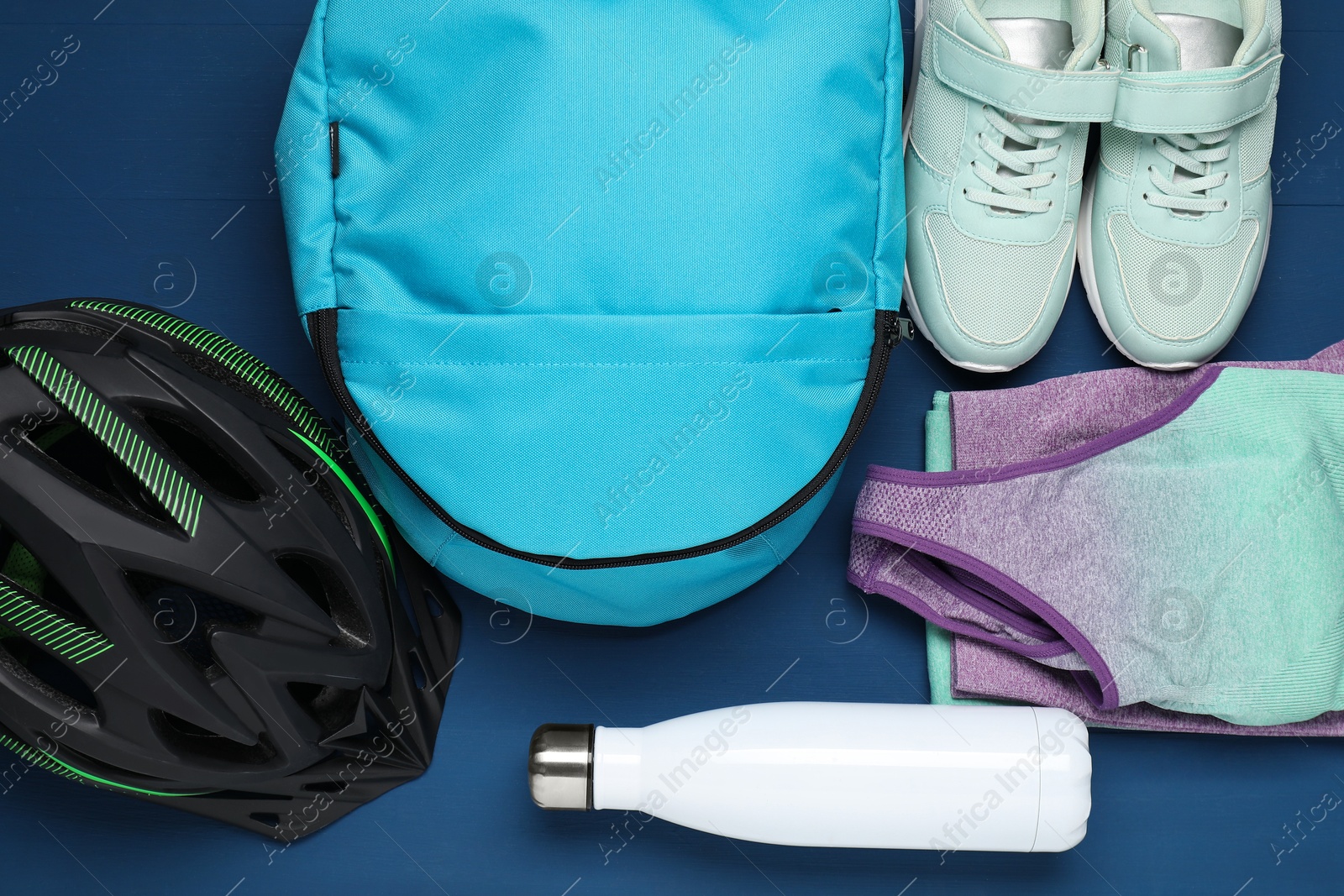 Photo of Flat lay composition with bicycle accessories on blue wooden background