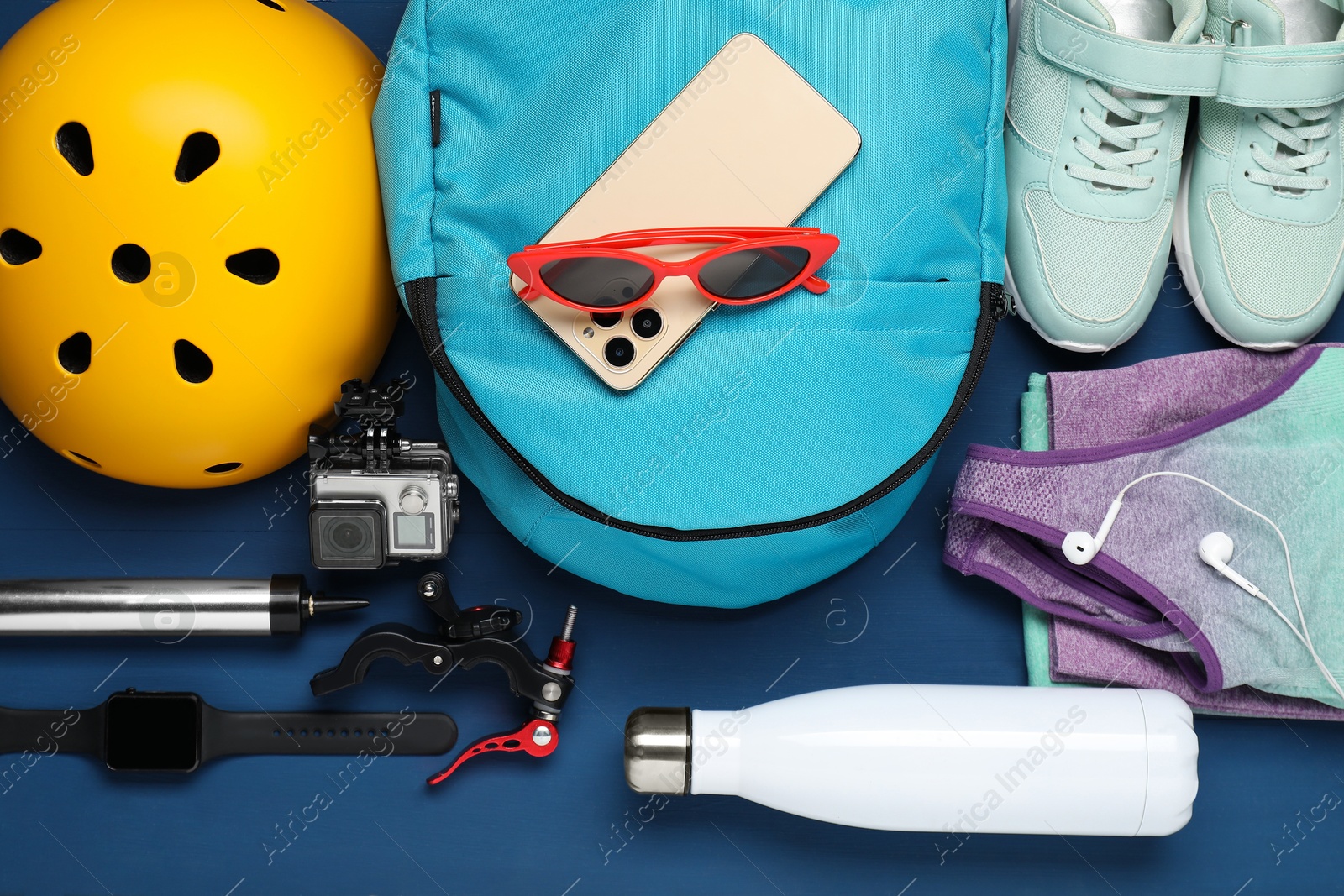 Photo of Flat lay composition with bicycle accessories on blue wooden background