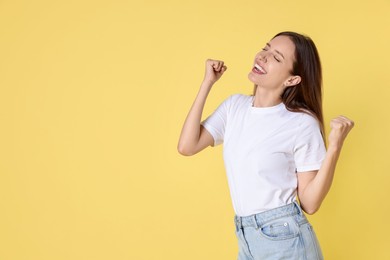 Photo of Happy winner on yellow background, space for text