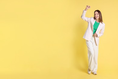 Photo of Portrait of happy winner on yellow background