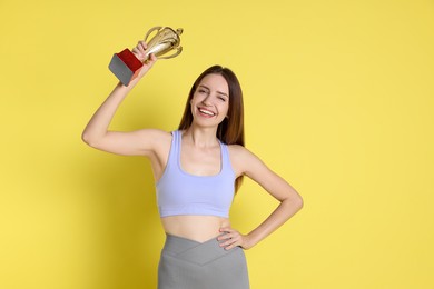 Happy winner with gold trophy cup on yellow background