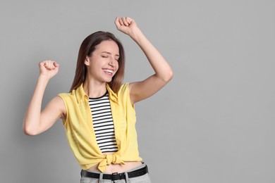 Portrait of happy winner on gray background