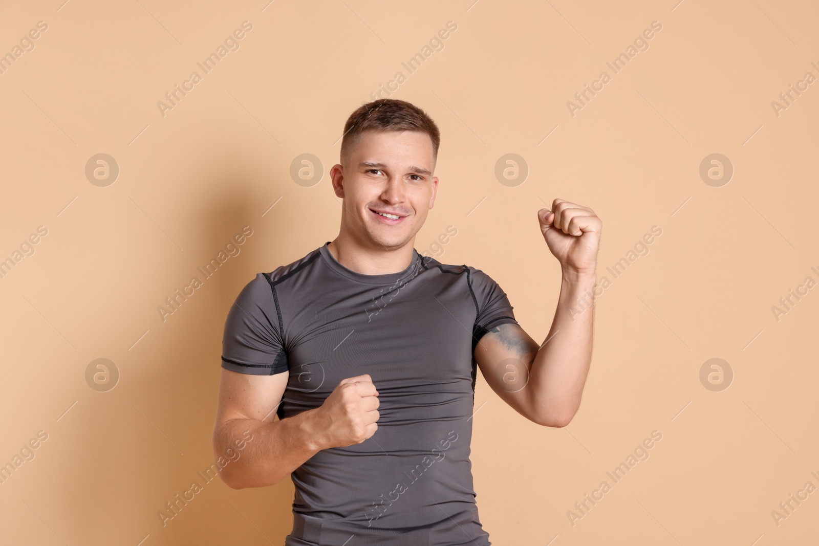 Photo of Portrait of happy winner on beige background