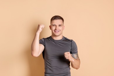 Photo of Portrait of happy winner on beige background