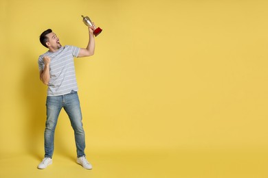 Photo of Happy winner with golden trophy cup on yellow background