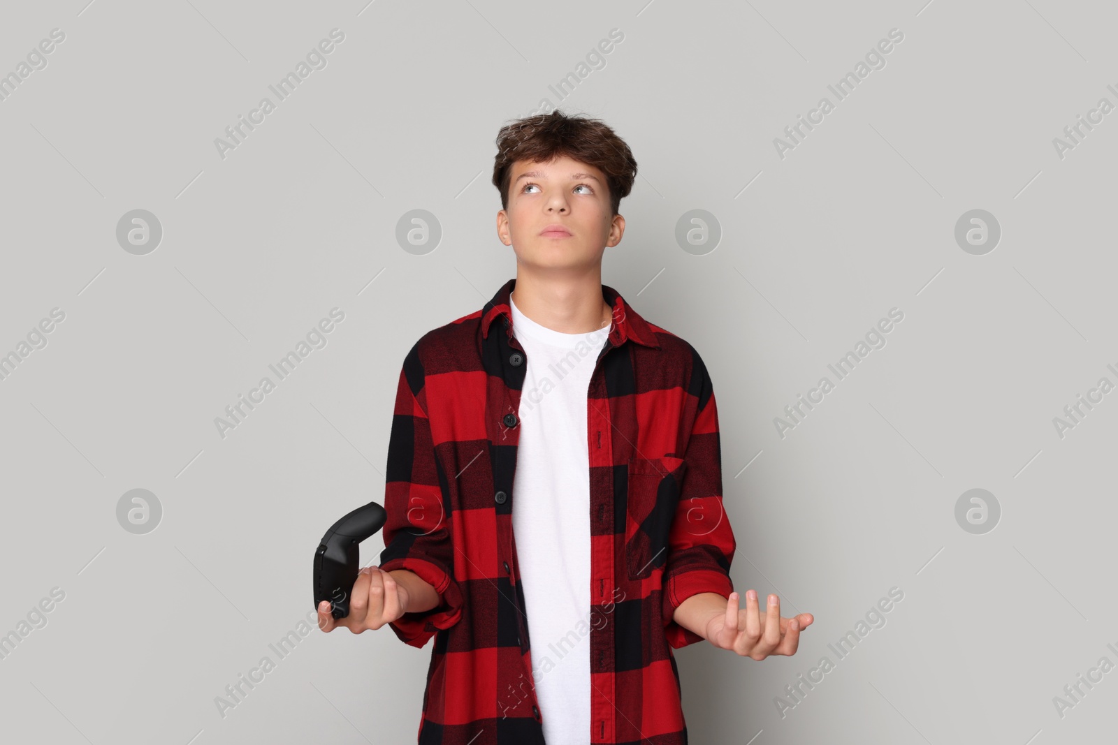 Photo of Teenage boy with controller on grey background