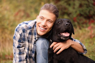 Photo of Smiling man with cute dog outdoors on autumn day