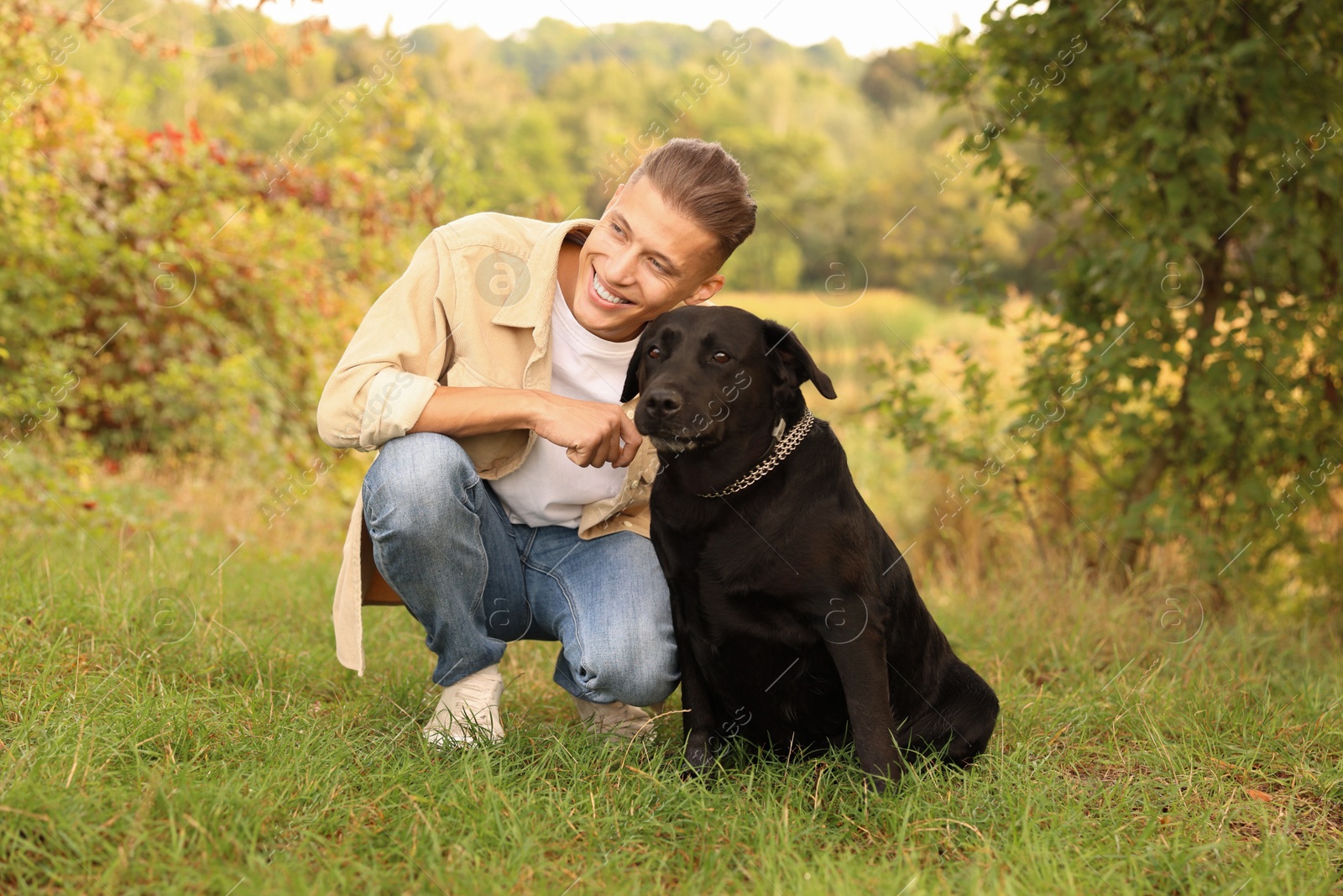 Photo of Smiling man with cute dog outdoors on autumn day