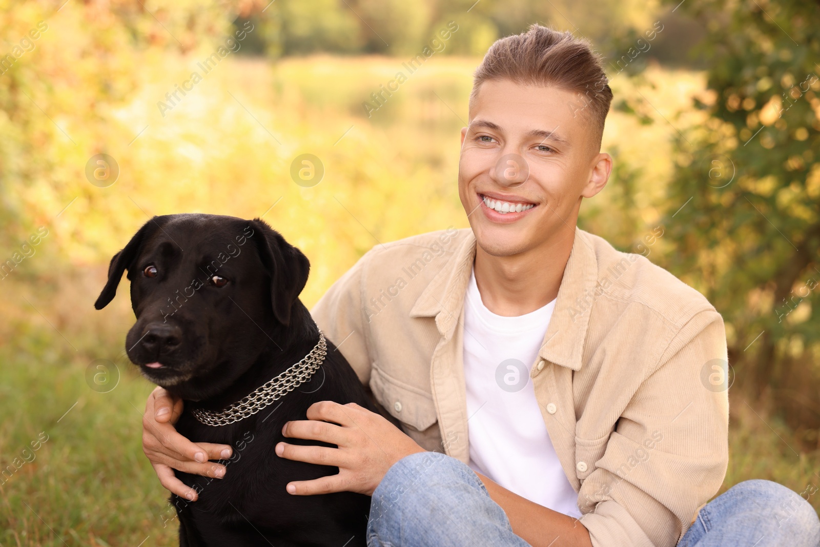 Photo of Smiling man with cute dog outdoors on autumn day