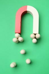 Photo of Magnet attracting human figures on green background, flat lay