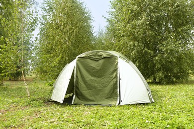 Photo of One camping tent on green grass outdoors