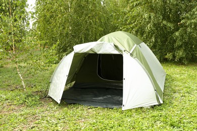 Photo of One camping tent on green grass outdoors