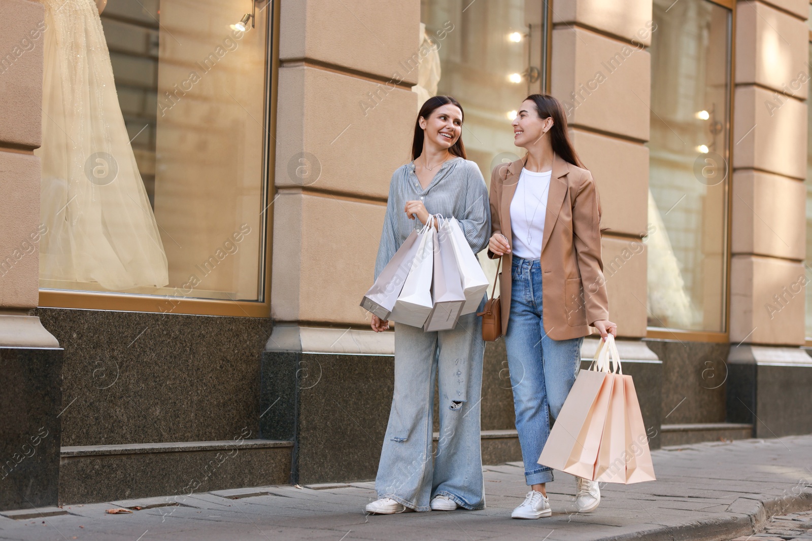 Photo of Happy women with many shopping bags outdoors