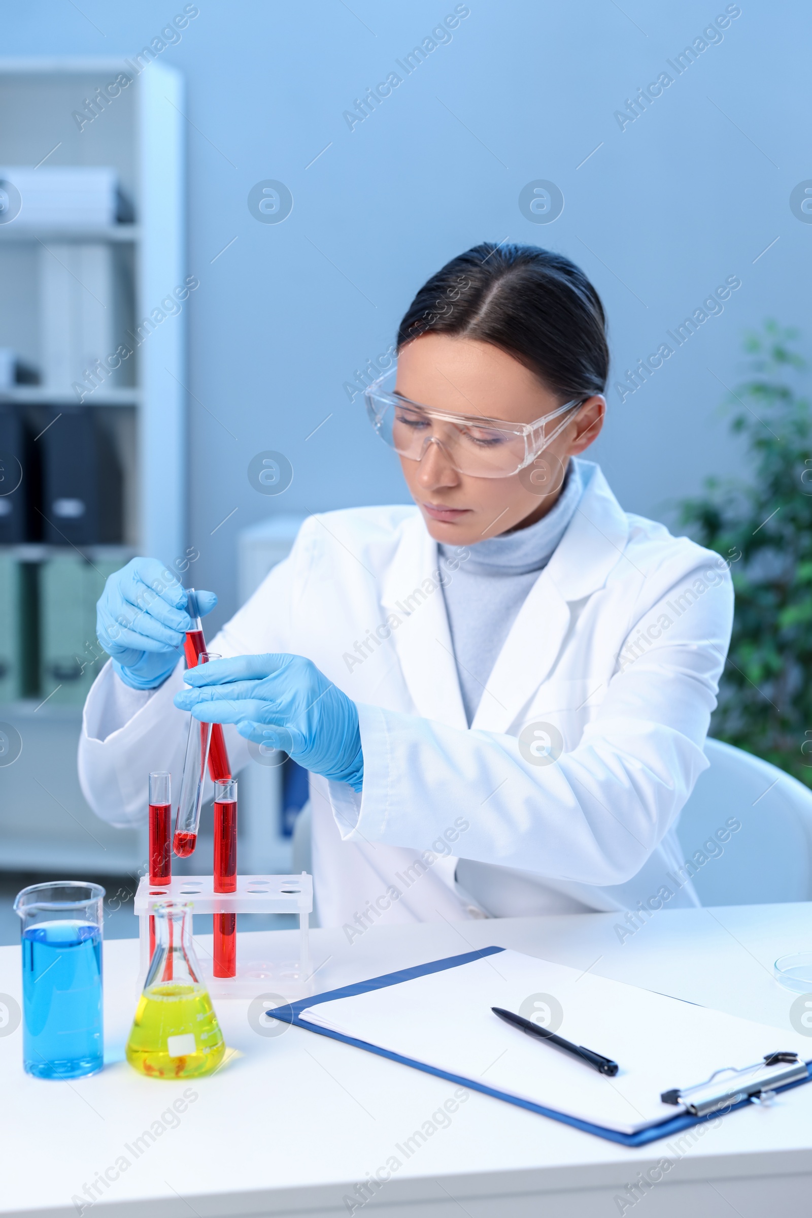 Photo of Laboratory testing. Doctor taking test tube with blood sample at table indoors