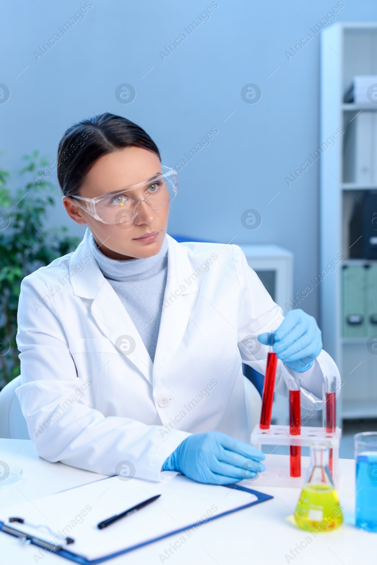 Photo of Laboratory testing. Doctor taking test tube with blood sample at table indoors