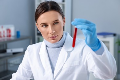 Photo of Laboratory testing. Doctor holding test tube with blood sample indoors