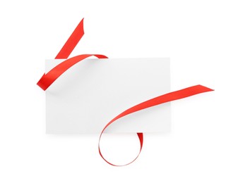 Photo of Blank card and red ribbon isolated on white, top view