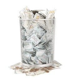 Photo of Many dollar banknotes in trash bin and coins isolated on white