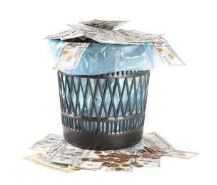 Photo of Many dollar banknotes in trash bin and coins isolated on white