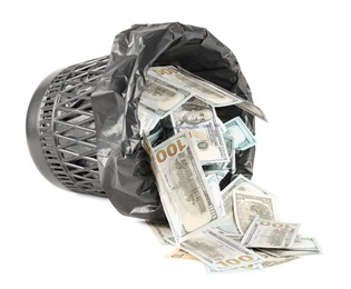 Photo of Many dollar banknotes and overturned trash bin isolated on white