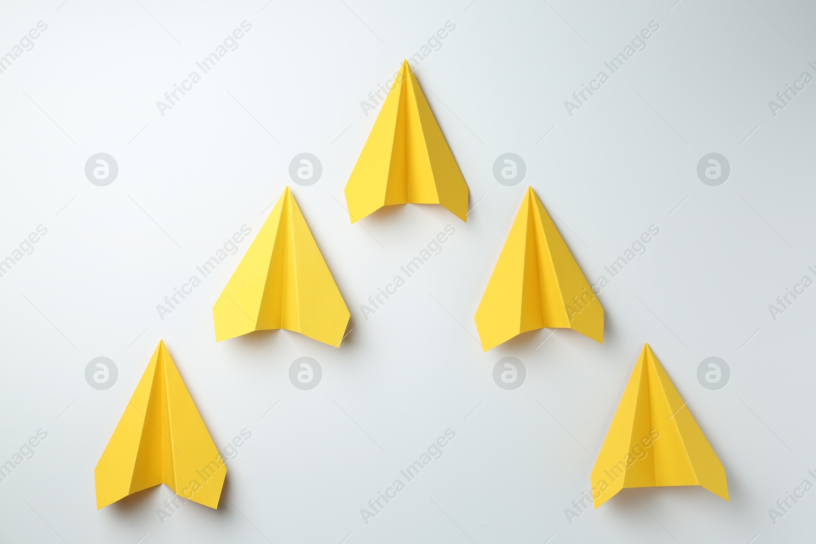 Photo of Handmade yellow paper planes on white background, top view