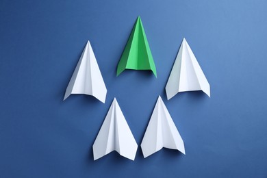 Photo of Handmade color paper planes on blue background, flat lay