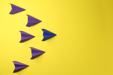 Photo of Handmade paper planes on yellow background, top view. Space for text