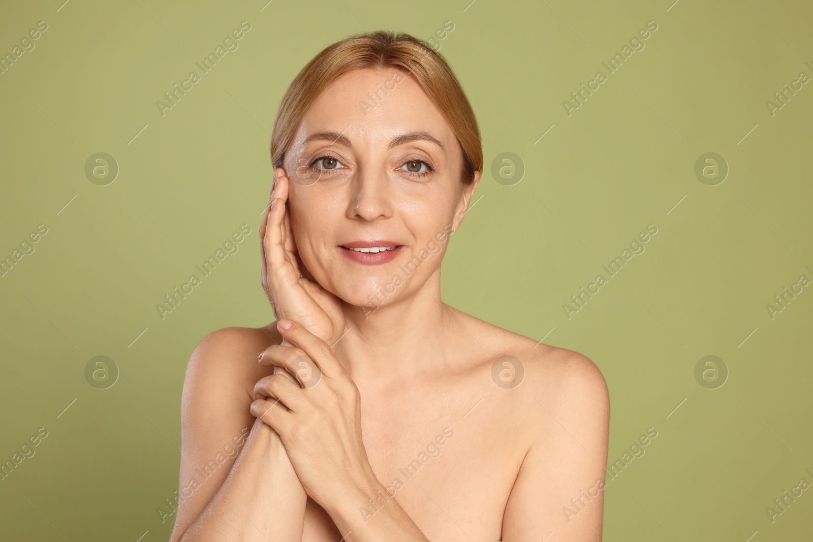 Photo of Portrait of smiling woman with healthy skin on green background