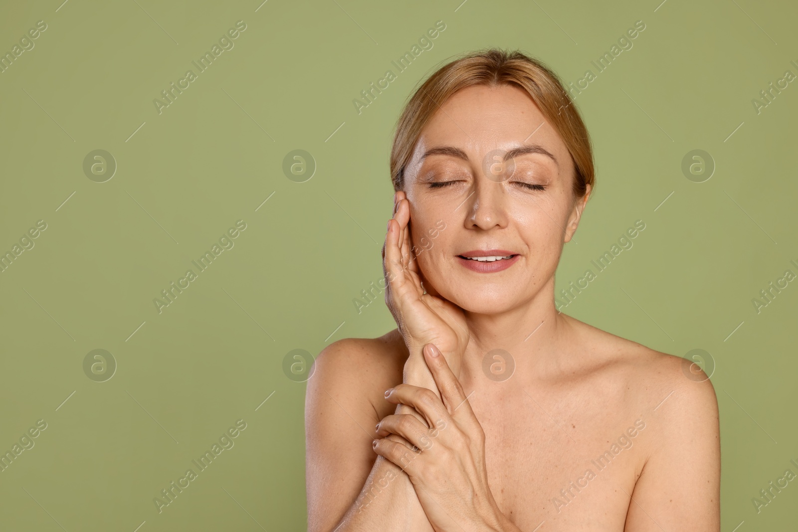 Photo of Portrait of smiling woman with healthy skin on green background