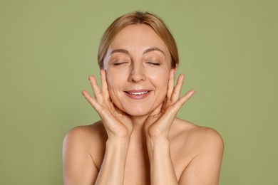 Photo of Portrait of smiling woman with healthy skin on green background