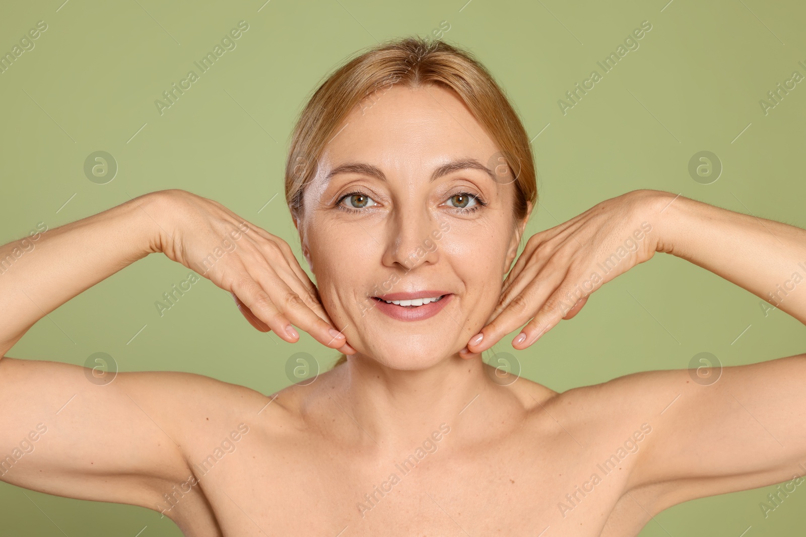 Photo of Portrait of smiling woman with healthy skin on green background